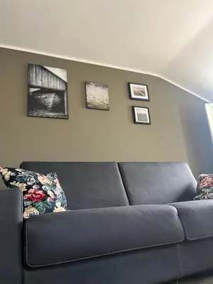a couch in a living room with pictures on the wall at Maison LuCe in Rome