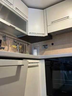 a kitchen with white cabinets and a black oven at Maison LuCe in Rome