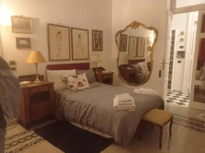 a bedroom with a bed with a mirror and a chair at Fiore73 in Rome