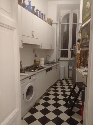 a kitchen with a washing machine and a checkered floor at Fiore73 in Rome