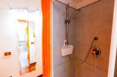 a shower in a bathroom with a shower head at Orange Nest in Rome
