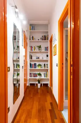 a hallway with white bookshelves with plants on them at Orange Nest in Rome