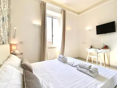 a bedroom with a white bed with towels on it at Prince of Rome Superior Rooms in Rome
