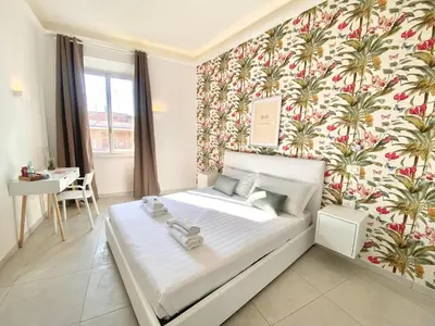 a bedroom with a bed with a floral wallpaper at Prince of Rome Superior Rooms in Rome