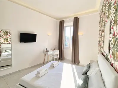 a white room with a bed and a tv at Prince of Rome Superior Rooms in Rome
