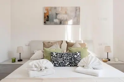 a white bed with two towels on top of it at Long Bridge Apartment in Rome