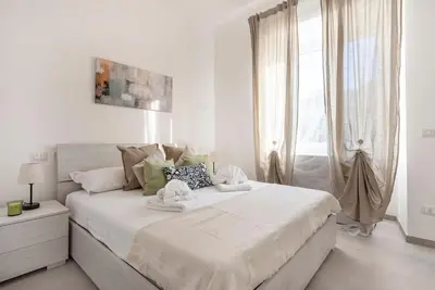 a white bedroom with a large bed with towels on it at Long Bridge Apartment in Rome