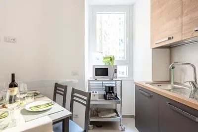 a kitchen with a table with chairs and a microwave at Long Bridge Apartment in Rome