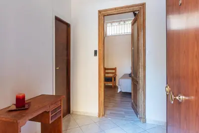 a room with a desk and a door with a bedroom at GuestHost - Piazza Nievo a Trastevere Cozy Apartment in Rome