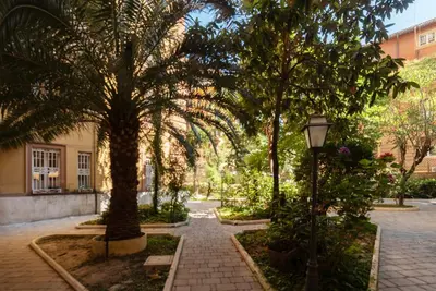 a courtyard with palm trees and a street light at GuestHost - Piazza Nievo a Trastevere Cozy Apartment in Rome