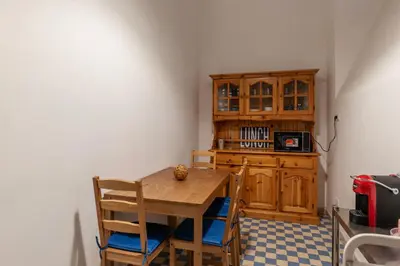 a kitchen with a wooden table and wooden cabinets at GuestHost - Piazza Nievo a Trastevere Cozy Apartment in Rome