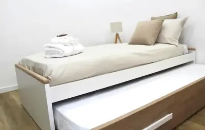 a white bed with a wooden frame in a room at Roman Location San Pietro in Rome