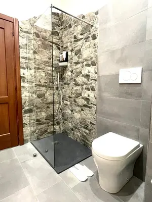 a bathroom with a toilet and a glass shower at Roman Location San Pietro in Rome