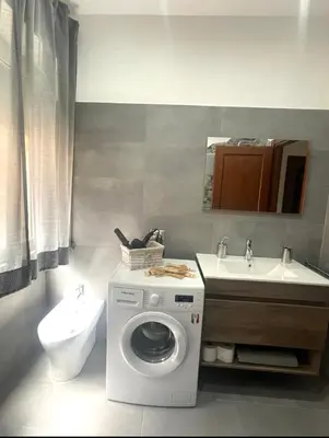 a bathroom with a washing machine and a sink at Roman Location San Pietro in Rome