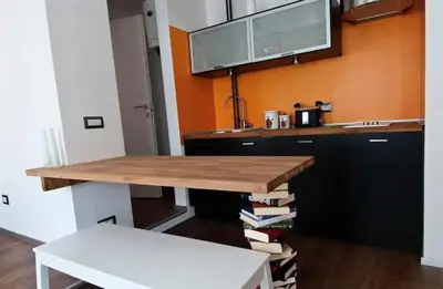 a kitchen with a wooden table with books on it at St Peter apartment - Sister's Place in Rome