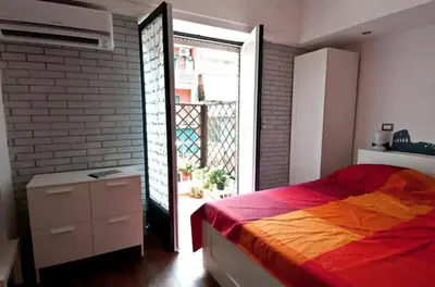 a bedroom with a bed and a door to a balcony at St Peter apartment - Sister's Place in Rome