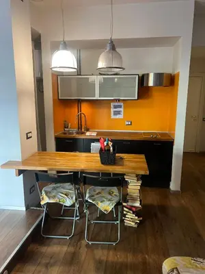a kitchen with a wooden table and two stools at St Peter apartment - Sister's Place in Rome