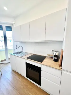 a white kitchen with a sink and a counter at Doria home-Saint Peter's View in Rome