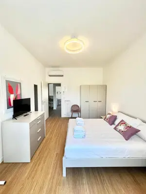 a bedroom with a bed and a desk and a television at Doria home-Saint Peter's View in Rome