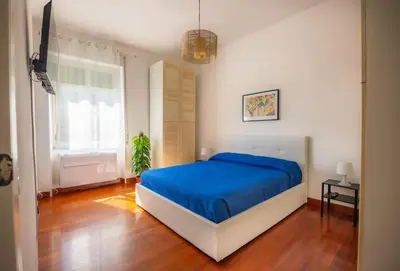 a bedroom with a bed with a blue blanket at Clodia Vatican House in Rome