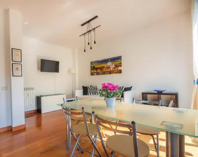 a dining room and living room with a table and chairs at Clodia Vatican House in Rome