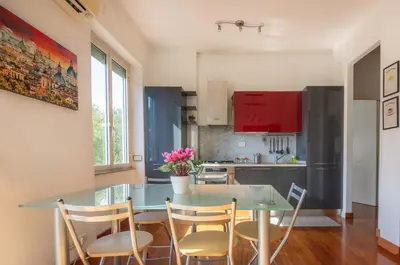 a kitchen with a glass table and chairs in a kitchen at Clodia Vatican House in Rome