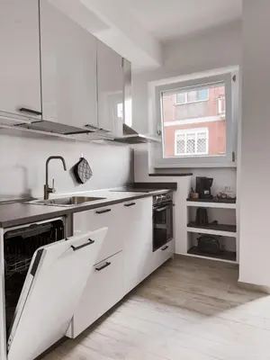 a kitchen with white cabinets and a sink and a window at Flora's Apartment in Rome