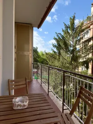 a balcony with a table and a bench on a balcony at Flora's Apartment in Rome