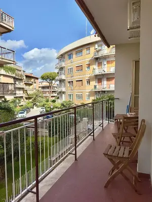 a balcony with two chairs and a table and a building at Flora's Apartment in Rome