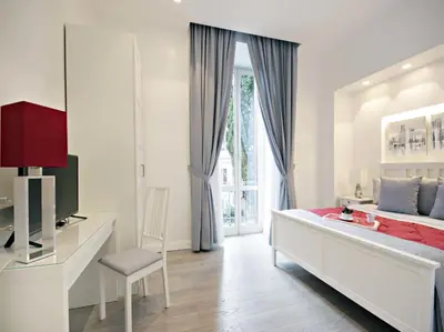 a white bedroom with a bed and a window at Velvet Trastevere Apartment in Rome