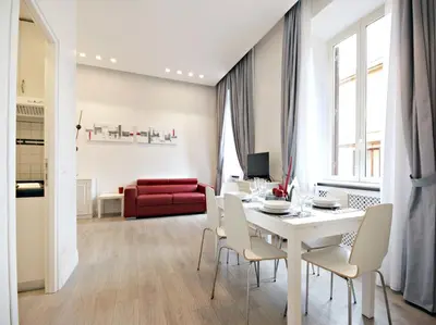 a dining room with a table and chairs and a red couch at Velvet Trastevere Apartment in Rome