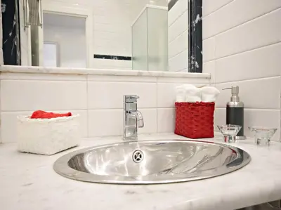 a bathroom sink with a red basket on it at Velvet Trastevere Apartment in Rome