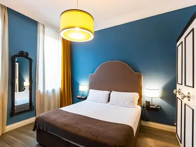 a bedroom with a large bed with a blue wall at JB Relais- Campo de' Fiori in Rome
