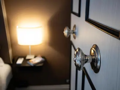 a room with a door with a lamp on a table at JB Relais- Campo de' Fiori in Rome