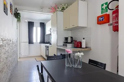 a kitchen with a table with vases of flowers on it at Casa Gemelli - Metro per il centro di Roma - in Rome