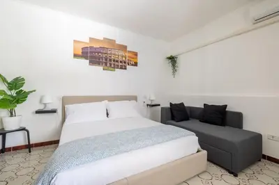 a bedroom with a large bed and a couch at Casa Gemelli - Metro per il centro di Roma - in Rome