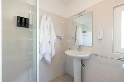 a white bathroom with a sink and a shower at Casa Gemelli - Metro per il centro di Roma - in Rome