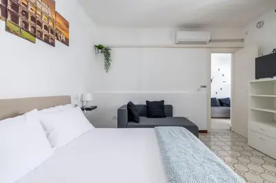 a white bedroom with a bed and a couch at Casa Gemelli - Metro per il centro di Roma - in Rome