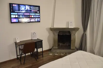 a bedroom with a desk and a fireplace with a tv at Roma Chic Cattolica Gemelli in Rome