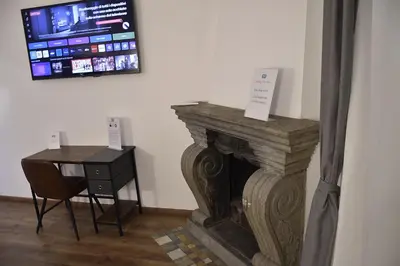 a room with a fireplace and a desk and a tv at Roma Chic Cattolica Gemelli in Rome