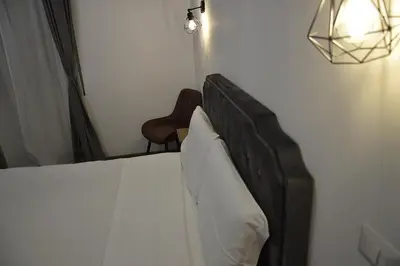 a bedroom with a bed with white sheets and a lamp at Roma Chic Cattolica Gemelli in Rome