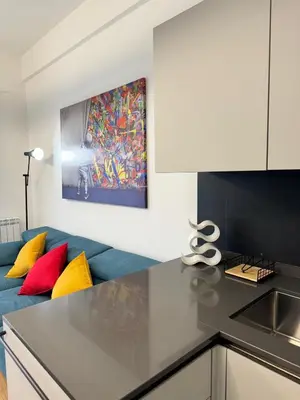 a kitchen with a blue couch with colorful pillows at Vatican R(h)ome in Rome