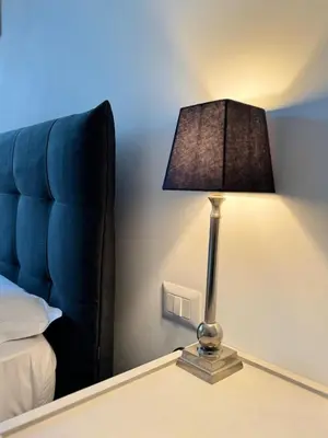 a lamp sitting on a table next to a bed at Vatican R(h)ome in Rome