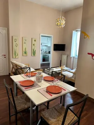 a dining room with a table with red plates and chairs at Casa Farina - Pretty Homes in Rome