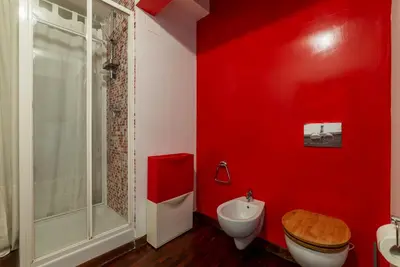 a red bathroom with a toilet and a sink at Casa Farina - Pretty Homes in Rome