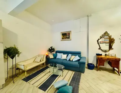 a living room with a blue couch and a table at CASA LORY Balduina in Rome