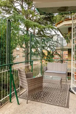 a patio with two chairs and a bench and a fence at CASA LORY Balduina in Rome