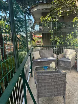 a balcony with wicker furniture and a table and chairs at CASA LORY Balduina in Rome