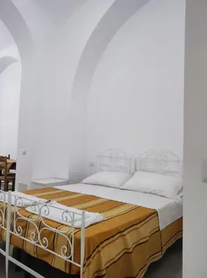 a white bedroom with a large bed with white pillows at Appartamento a San Lorenzo Netsuhe in Rome