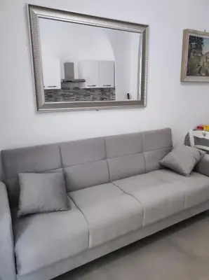 a couch in a living room with a mirror at Appartamento a San Lorenzo Netsuhe in Rome